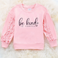 Kids pink ruffle sleeve sweatshirt with 'Be Kind to Yourself' message, featuring soft fabric and playful ruffles for a stylish and comfortable everyday outfit.